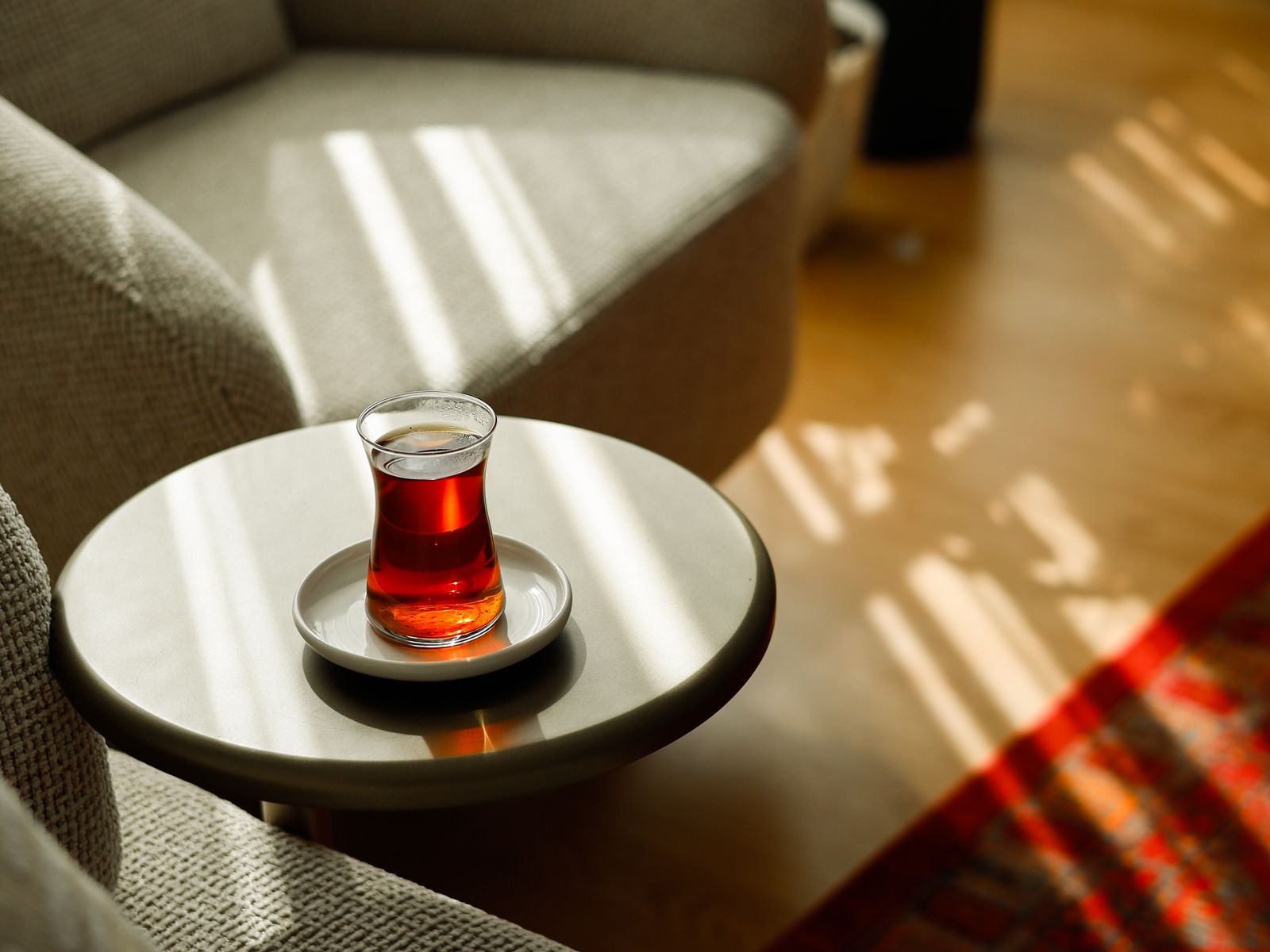 Plush lounge seating beside a side table with tea in warm daylight