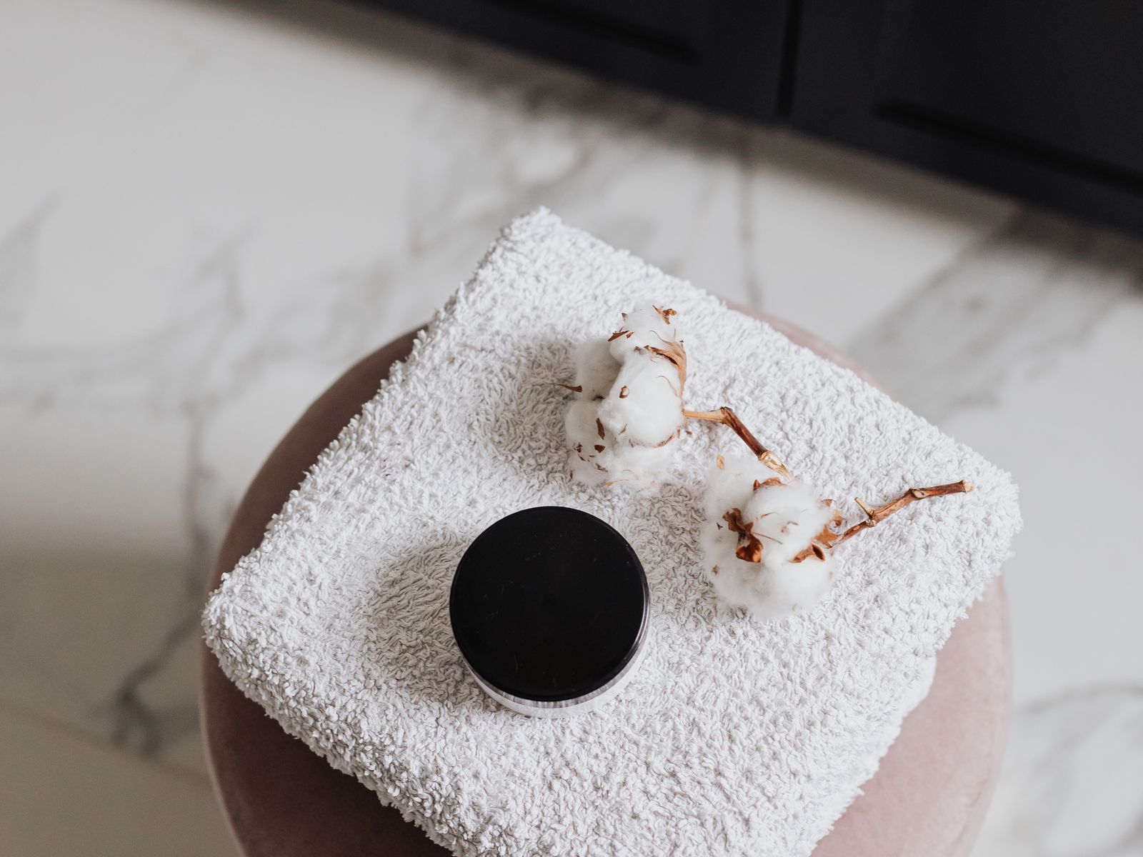 Folded spa towel and candle on marble